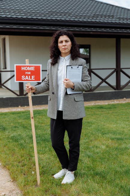 Female real estate agent outside house for sale holding sign.